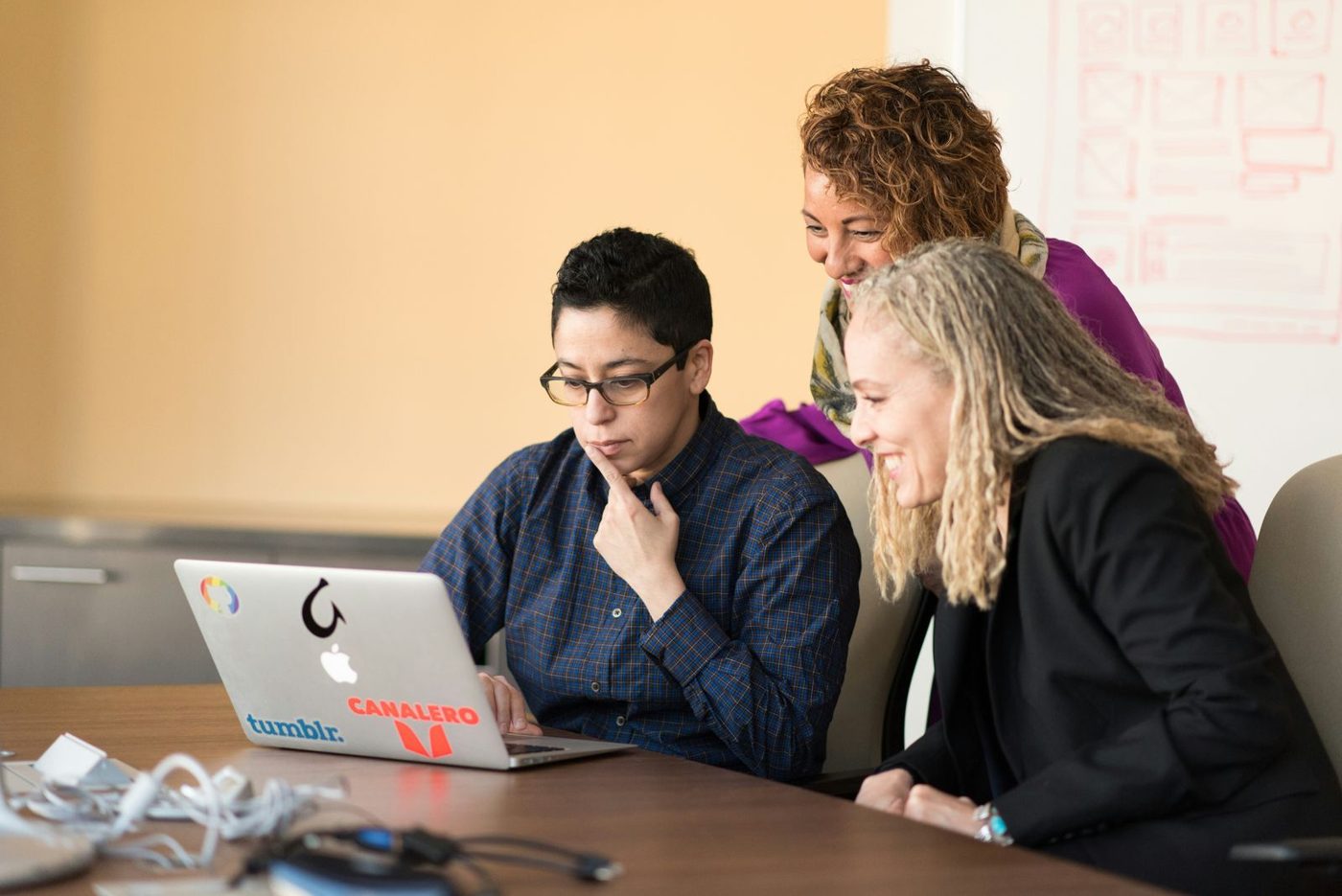 Tres personas revisan juntas algo en una laptop