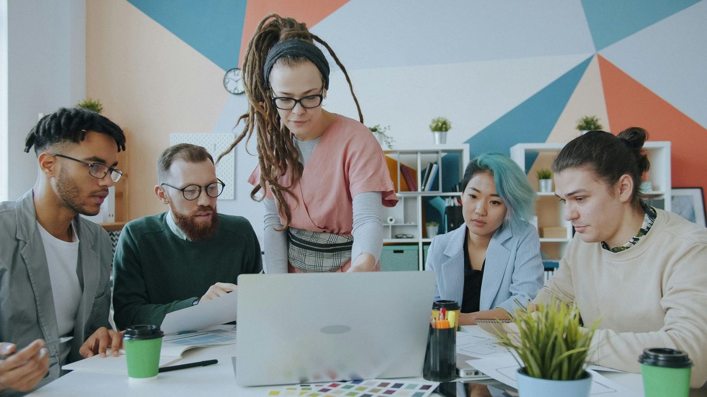 Un equipo revisa ideas alrededor de una laptop